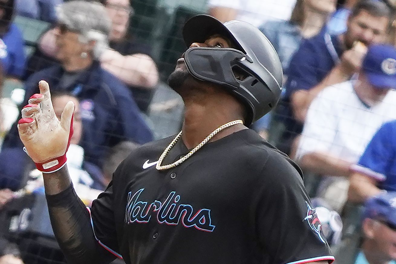 Miami Marlins right fielder Jorge Soler (12) gestures as he crosses home plate after hitting a home run against the Chicago Cubs during the third inning at Wrigley Field.