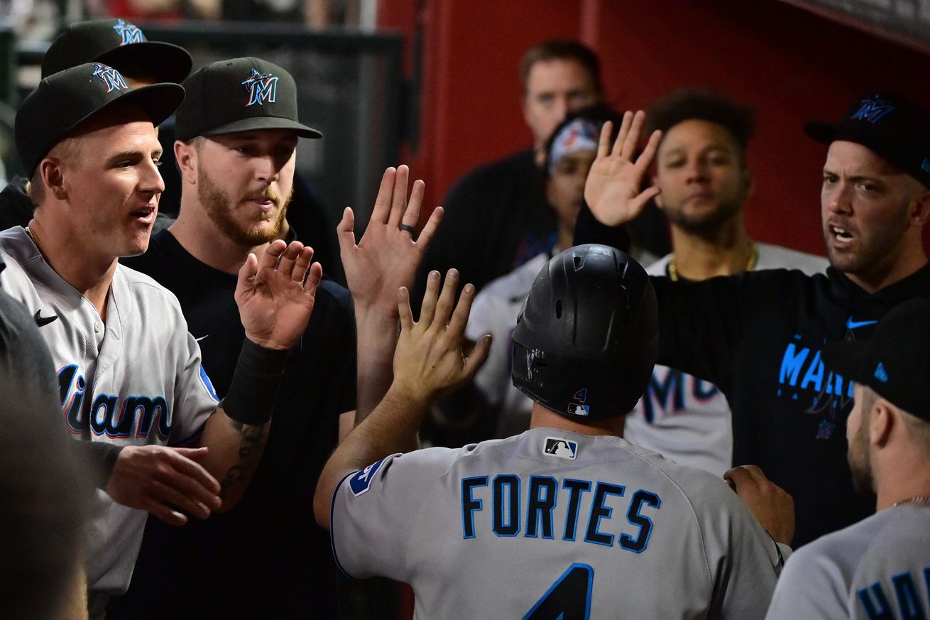 Miami Marlins catcher Nick Fortes (4) celebrates with teammates after scoring in the fifth inning against the Arizona Diamondbacks at Chase Field.