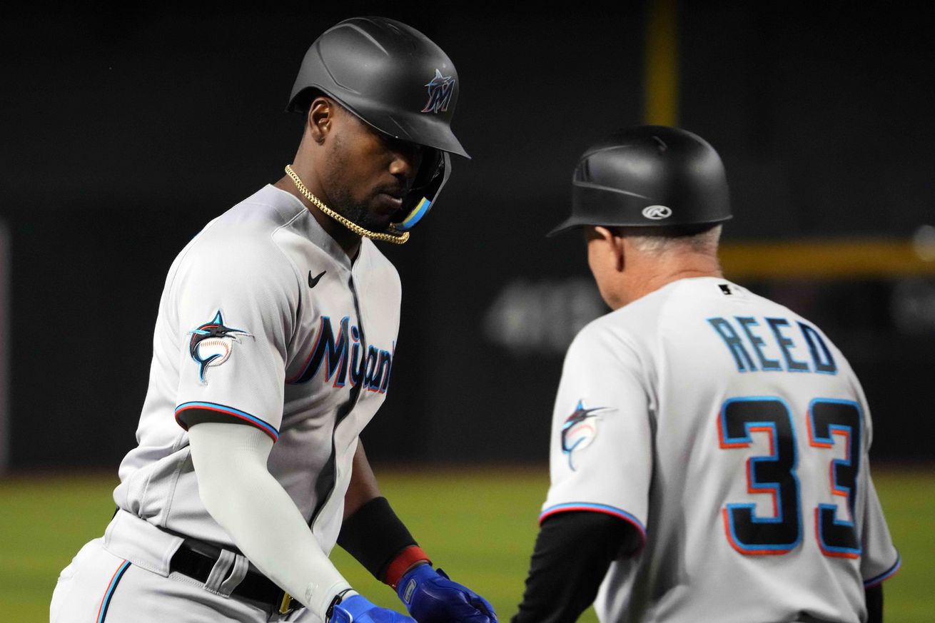 Marlins designated hitter Jorge Soler (12) slaps hands with Miami Marlins third base/infield coach Jody Reed (33) after hitting a home run against the Arizona Diamondbacks during the fifth inning at Chase Field.